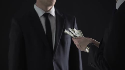 Man Receiving Money in Dark Setting