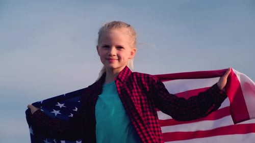 Girl Smiling with the American Flag Outdoors