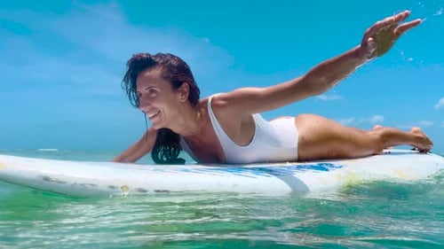 Woman Paddling Surfboard in Tropical Ocean