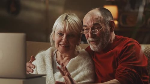 Senior Couple Video Calling On Laptop At Home