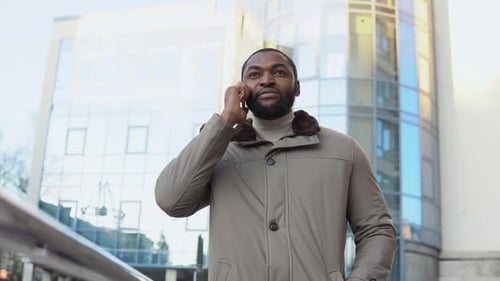 Elegant Bearded Businessman Talking on Phone Near the Office Center