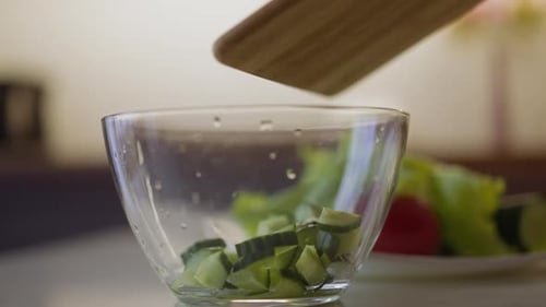 Pouring Sliced Cucumbers into Bowl for Salad