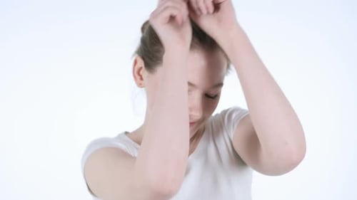 Young Woman Dancing Happily in White Studio