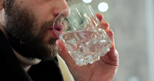 Man Drinks Water From Crystal Glass Indoors