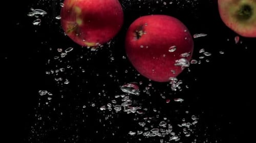 Slow Motion Three Red Apple Falling Into Transparent Water on Black Background