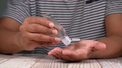 Close Up of Young Man Hand Using Sanitizer Gel for Preventing Virus