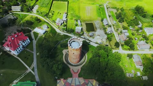 Flug über eine Provinzstadt. Ein alter Turm unter den bunten Dächern von Häusern