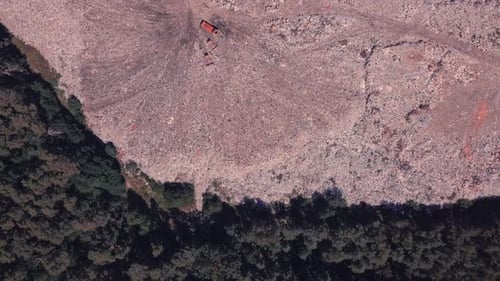 Abstieg über die Mülldeponie an der Grenze zum Wald, über die Vögel fliegen und Maschinen arbeiten