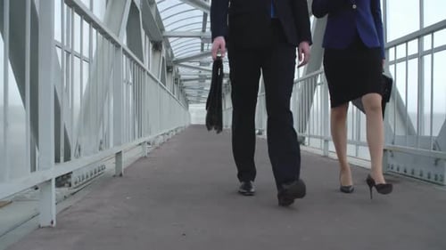 Business People Walking, Talking on Enclosed Walkway