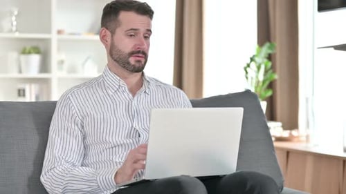 Man Working on Laptop from Home on Couch