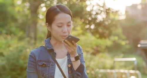 Young Woman Uses Smartphone in Park Setting