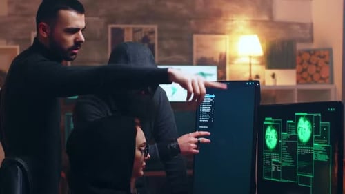 Team von Hackern betrachtet Computer mit mehreren Monitoren