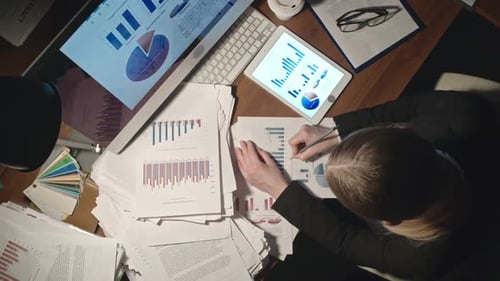 Businesswoman Analyzing Data and Charts in Office
