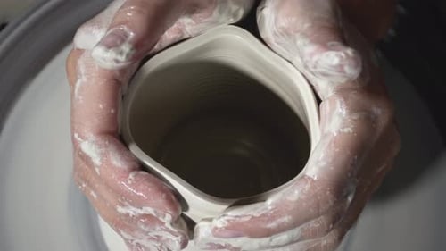 Hands Shape White Clay on Potter's Wheel