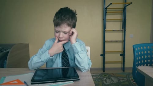 Two Children Studying at Desks in a Classroom