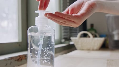 Coronavirus pandemic close up on hands using hand sanitizer to prevent infection