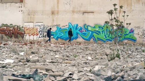 Jovens lutando em frente a paredes pintadas de grafite.