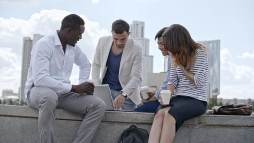 Diverse Business Group Using Laptop at Informal Meeting Outdoors