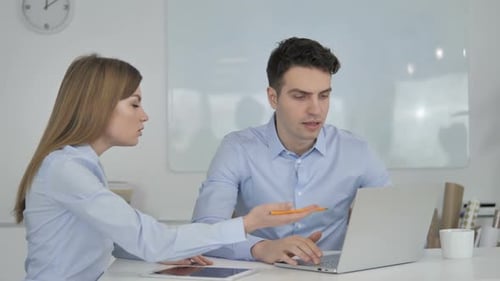 Business Colleagues Discussing Project at Office Desk