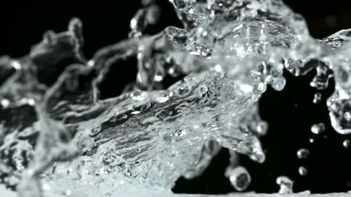 Powerful Water Splash with Ice Against Black Background