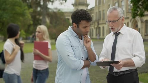 Math Teacher Explaining Tasks to Mixed-Race Student Near University, Education
