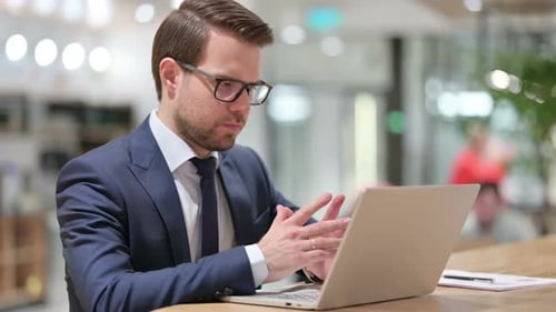 Man in Suit Working on Laptop in Office