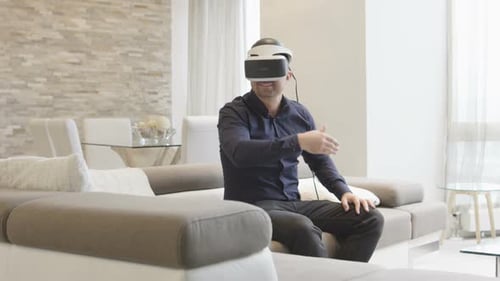 Man Experiencing Virtual Reality with Headset on Couch