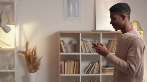 Young Man Using Smartphone Indoors During the Day