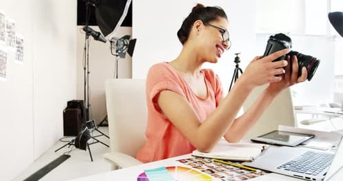 Photographer Smiles While Holding Camera in Bright Studio