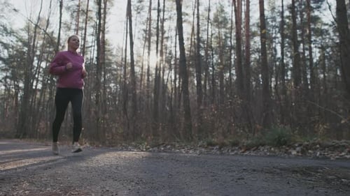 Caucasian Woman Jogging in the Autumn Forest