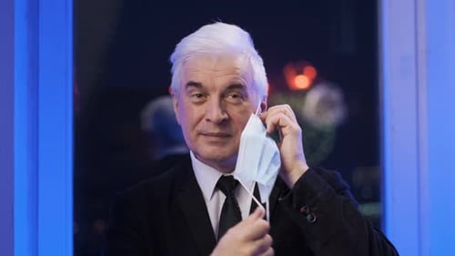 Adult Takes Off Surgical Mask at Night