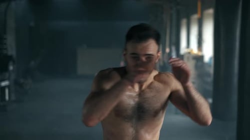 Aggressive Professional Fighter Training Shadow Boxing Throwing a Vicious Blow. A Young Champion Is