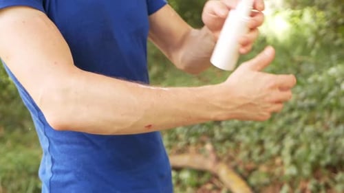 Adult Applying Topical Cream to Arm Outside