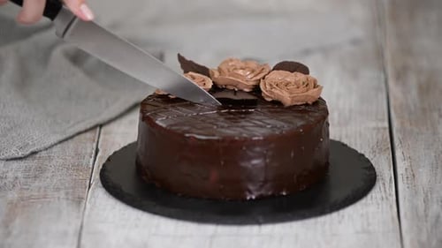 Woman Cutting a Delicious Chocolate Prague Cake