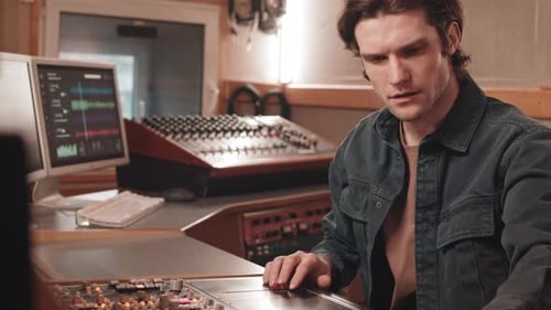 Man Using Mixing Console at Music Record Studio