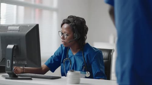 Woman Healthcare Worker At Computer In Office