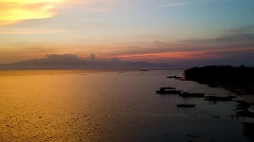 Aerial of epic Sunset and silhouettes of boats from Paliton Beach, Siquijor, Cebu, Philippines