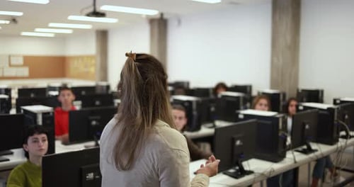 Young multiracial students using computers at school class