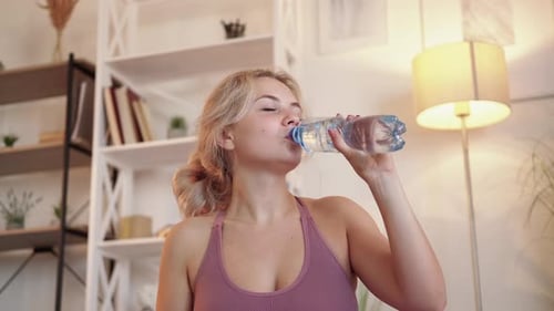 Woman Drinks Water in Her Home