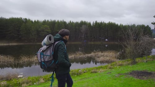 Young Adult Hiking with Backpack by Lake