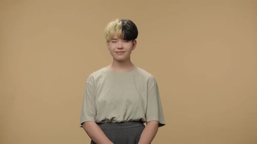 Smiling Teen with Two-Tone Hair Standing Indoors
