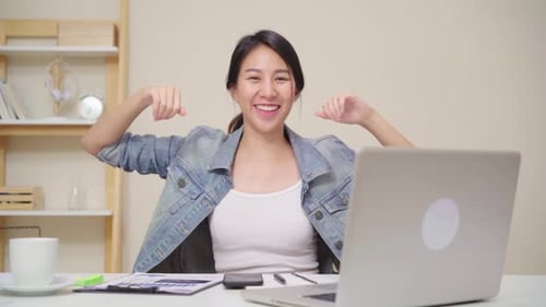 Excited Young Woman Celebrating Success at Desk