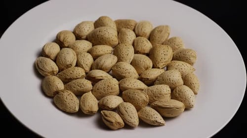 Delicious Almonds in Shells on White Plate