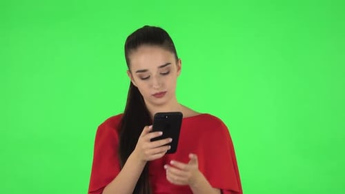 Young Woman Using Smartphone on Green Screen
