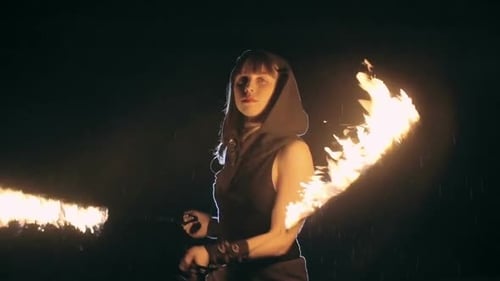Young Woman Spinning Flaming Torches at Night