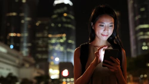 Woman Using Smartphone at Night in City