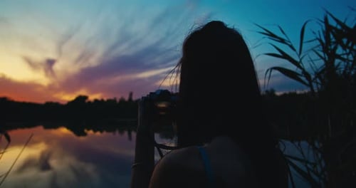 Woman Taking Pictures of Lake During Tropical Sunset