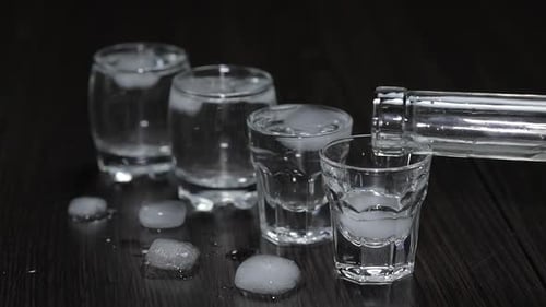 Pouring Alcohol Into Shot Glass with Ice
