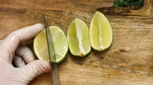 Die Arme des Barkeepers fügen frischen Saft in transparentes Glas mit grüner Minze und Limettenscheiben hinzu