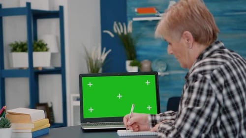 Elderly Person Reading on Green Screen Mock Up Chroma Key Display of Laptop